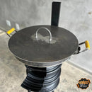 Churrasqueira artesanal de ferro com tampa redonda e alças amarelas, design robusto