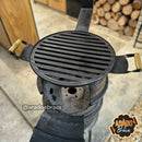 Churrasqueira de tambor com grelha metálica redonda e alças de madeira em área externa