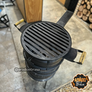 Churrasqueira a carvão preta com grelha redonda e alças de madeira em área externa